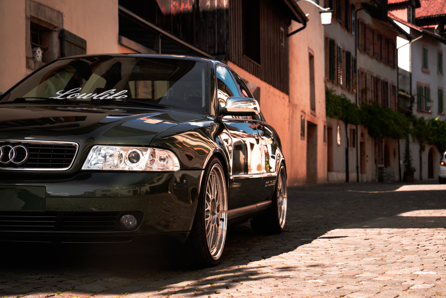 Tiefergelegter Audi 80 mit Lowlife-Schriftzug auf der Frontscheibe in einer Schweizer Altstadt