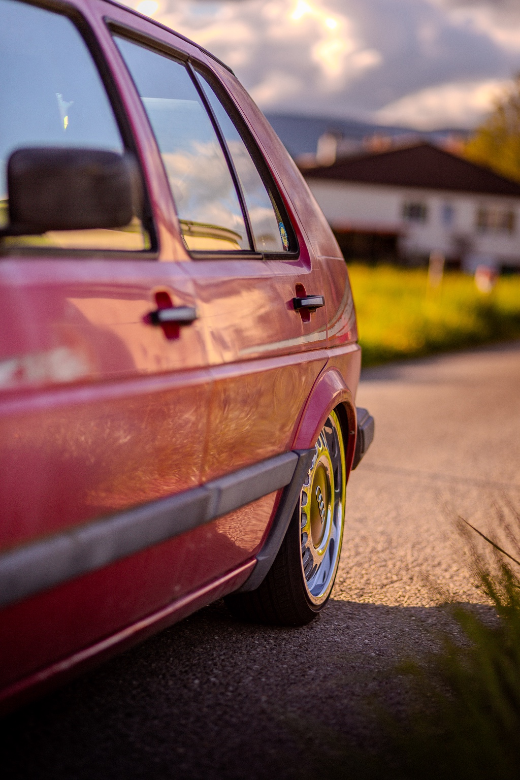 Originaler pinker VW Golf II von der Seite mit tiefem Fahrwerk und historischen Felgen
